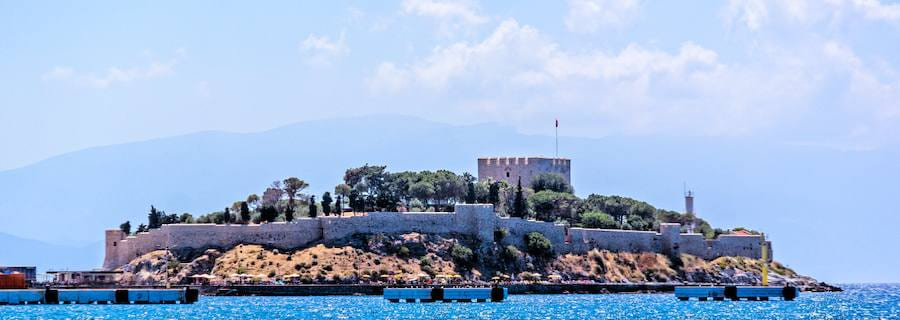 La isla de Güvercinada en Kuşadası con sus murallas y su torre de fortaleza otomana sobre el mar Egeo
