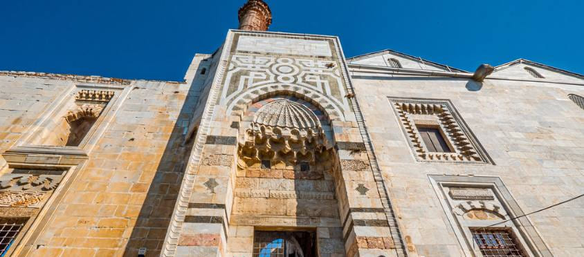 El portal de mármol tallado de la Mezquita İsa Bey, con su bóveda de mocárabes