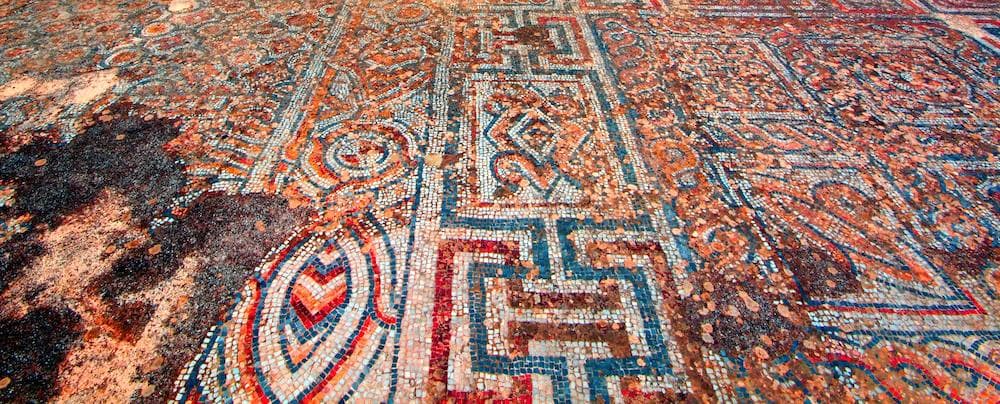 Suelo de mosaico romano en Éfeso con dibujos geométricos en teselas rojas, azules y blancas