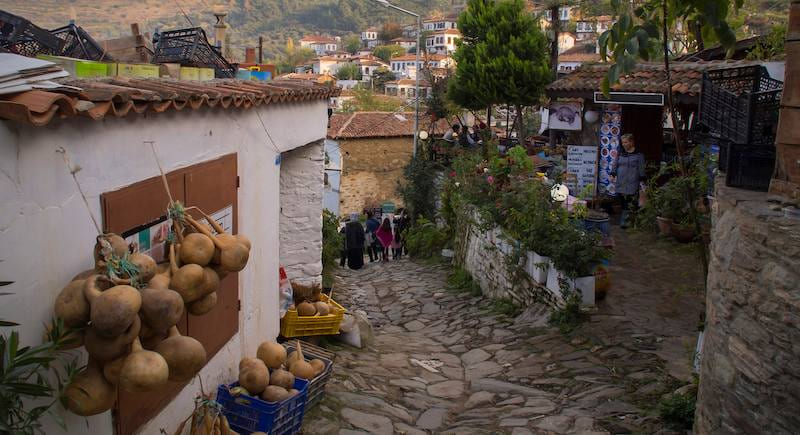 Calabazas secas y cerámica pintada en una callejuela empedrada de Sirince